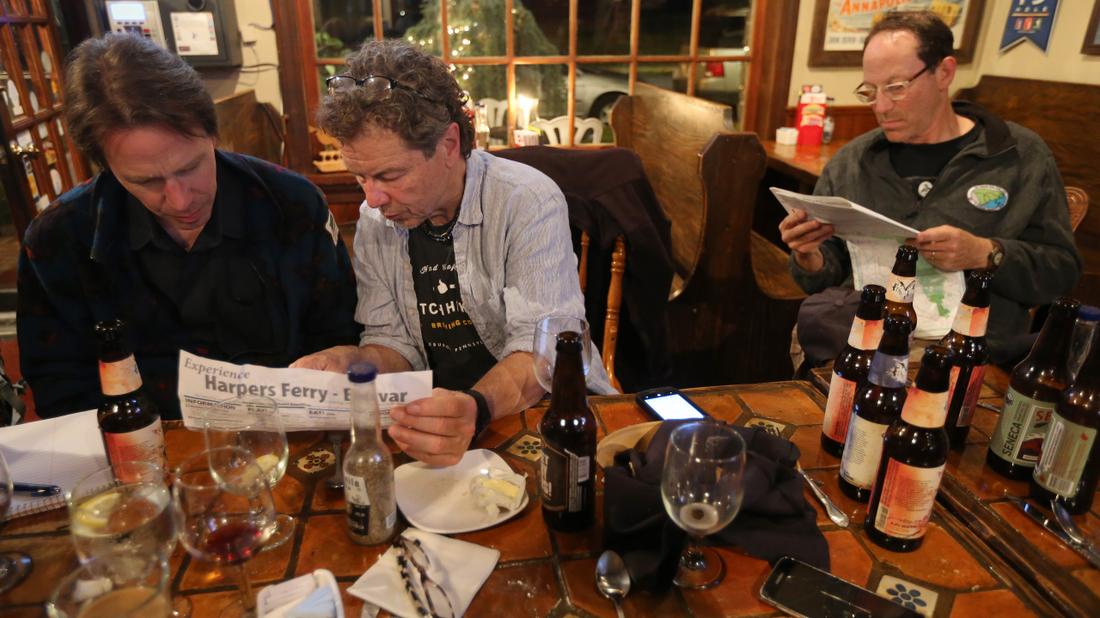 After dinner and drinks, Bo Emerson (from left), Don Hopey and Scott Huler study maps and try to decide where on the Appalachian Trail to hike during the Appalachian Adventure reunion. Ben Gray / bgray@ajc.com