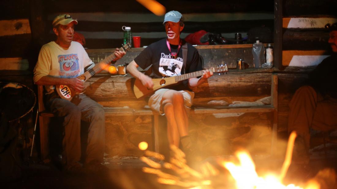 With a roaring fire to keep warm in the cool evening air, Walter Cumming and Bo Emerson jam well past sundown at the Rocky Run shelter.  Ben Gray / bgray@ajc.com
