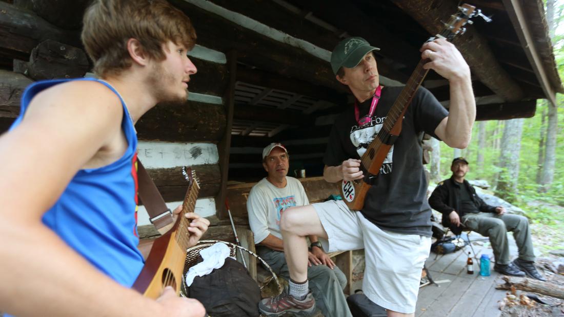 Thru-hiker Alex "Superman" Robinson, left, who was also staying at the Rocky Run shelter, heard music and stopped by,  borrowed a hiker guitar and jammed with Bo Emerson. Robinson, who is from Maine, said he missed his guitar and was planning to meet up with his parents, who were bringing him a hiker guitar to carry for the rest of his hike. Ben Gray / bgray@ajc.com