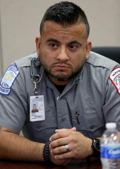 Grady EMT John Arevalo assisted Brantly on his walk into Emory Hospital. AJC File photo