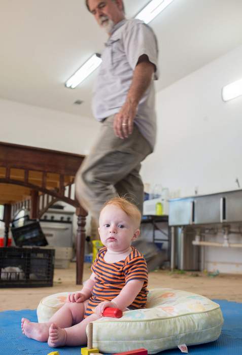 Six-month-old Noah Brett plays on the packing house floor at DaySpring Farms in Madison County.