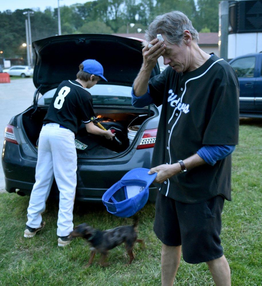 Championship game over, the coach mops his brow and lets Reuben do the hard work. The family dog, Scrapper, swirls about his feet. The Wolves’ championship season reminded Davis of an earlier season when he played. His coach? A man named Davis.  Brant Sanderlin / bsanderlin@ajc.com