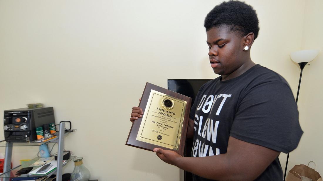 Walter shows off a plaque for his Fine Arts Award from B.E.S.T Academy. Kent D. Johnson/AJC